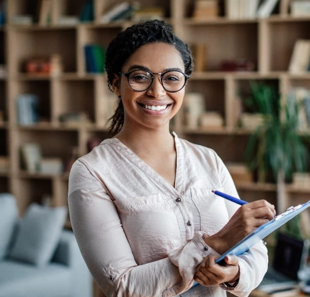 woman smiling in front of bookshelf square